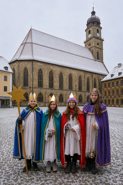 Auf dem Bild sind vier Sternsinger vor der Basilika St. Martin zu sehen.