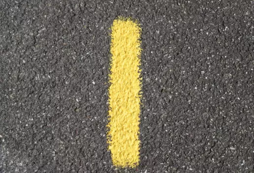 Das Bild zeigt die Zahl Eins in gelb auf einer Straße.