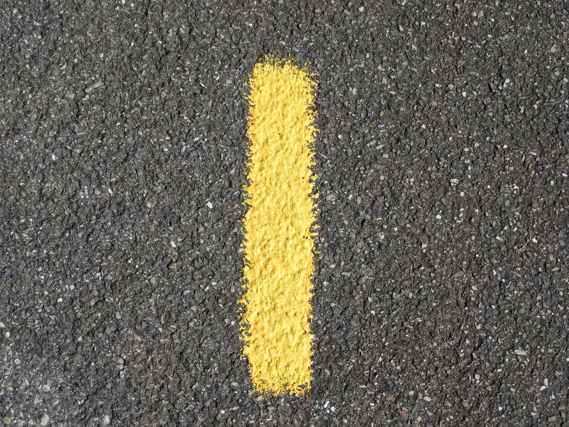 Das Bild zeigt die Zahl Eins in gelb auf einer Straße.